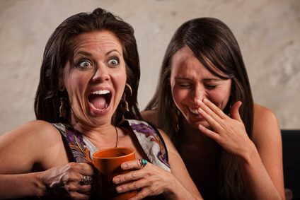 Screaming woman holding coffee mug next to laughing friend
