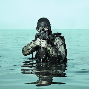 Navy SEAL frogman with complete diving gear and weapons in the water
